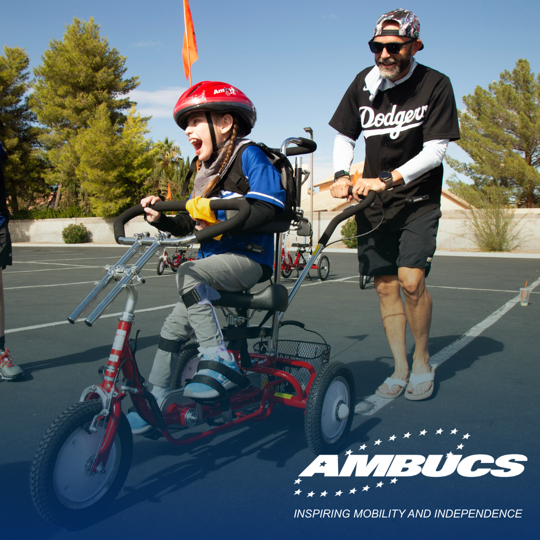 Two volunteers kneel to fit a young boy on an adaptive tricycle
